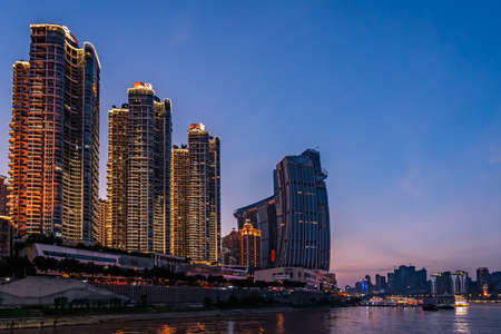 Chongqing, China -  August 2019 : Night view of the modern commercial and business buildings on the riverside at duskのeditorial素材