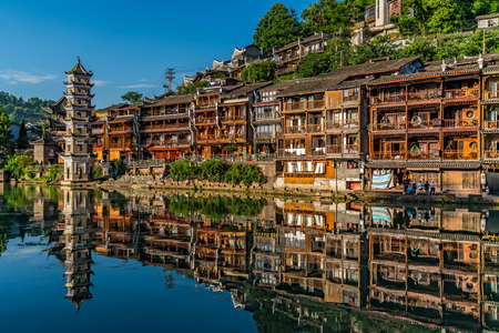 Feng Huang, China -  August 2019 : Landmark Fenghuang Wanming Pagoda Tower and old heritage wooden houses on the riverbank of Tuo river, flowing through the centre of Feng huang Old Townのeditorial素材