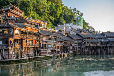 Feng Huang, China -  August 2019 : Old historic wooden Diaojiao houses on the riverbanks of Tuo river, flowing through the centre of Fenghuang Old Townのeditorial素材