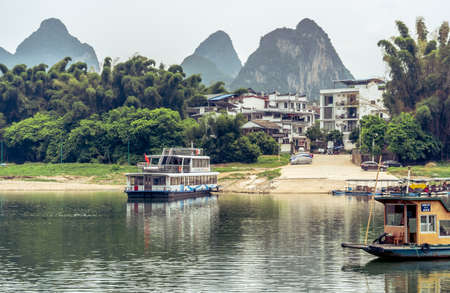 Yangshuo, China - August 2019 : Image of a ferry boat waiting for passengers on the  shore of the Li river in summerのeditorial素材
