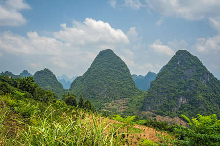 Beautiful green, lush, tropical and dense karst mountain peaks and landscape in Yangshuo, Guangxi Province, Chinaの写真素材