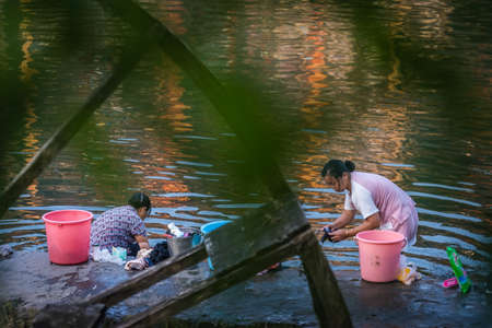 Feng Huang, China -  August 2019 :  Feng Huang, China -  August 2019 : Chinese women doing laundry on the riverbank of Tuo river,  Feng huang Old Townのeditorial素材