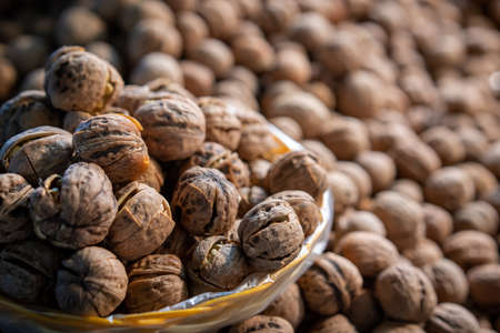 Bunch of fresh walnuts in a wicker bowl for sale on a street market in Chinaの写真素材