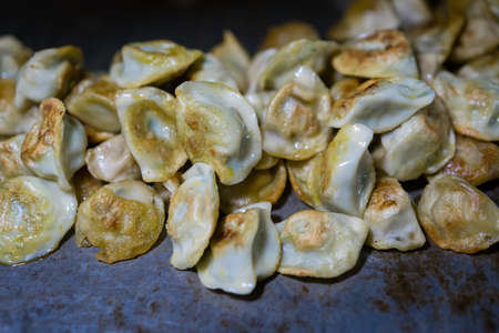 Delicious traditional chinese dumplings filled with pork meat, prepared on hot plate on a street stand, Chinaの写真素材
