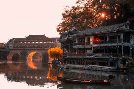 Feng Huang, China -  August 2019 : Morning view of the old historic arched bridge on the riverbanks of Tuo river, flowing through the centre of Fenghuang Old Townのeditorial素材