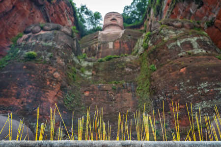 Leshan, China - July 2019 : Memorial candles lit at the bottom of The Giant Leshan Buddha, a 71-meter tall stone statue built between 713 and 803 during the Tang Dynasty. Sichuan provinceのeditorial素材