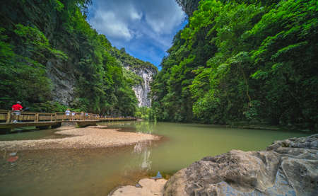 Red autumn leaves on a trees growing in front of Giant Waterfall in a valley gorge in the Longshuixia Fissure National park, Wulong country, Chongqing, Chinaのeditorial素材