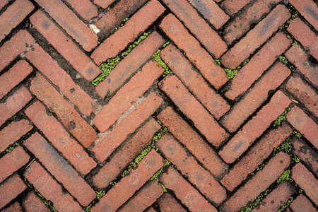 Pattern of old bricks layered in a pattern on the pavement and road, can be used as background or...