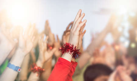 Cheering crowd of happy children with hands in the air at the school disco party at Christmas timeの写真素材