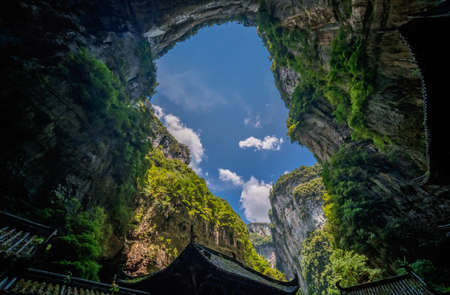 Traditional chinese architecture pagoda buildings in front of the stone arch among the karst rocky landscape of Wulong National Park, Chinaの写真素材