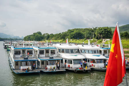 Guilin, China - August 2019 : Sightseeing boats waiting for tourists on the riverbank of the...