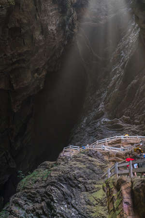 Wulong, China - August 2019 : Tourists climbing steps inside a stunning massive cave in a canyon among karst landscape of the Wulong National Parkのeditorial素材