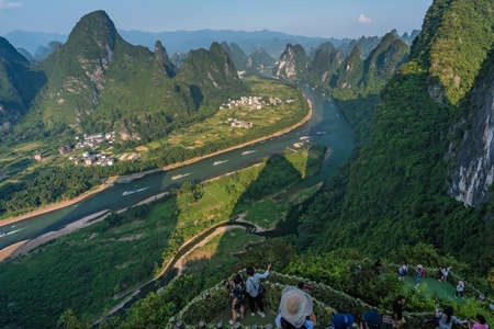 Yangshuo, China - August 2019 : Tourists admiring stunning panoramic view of the beautiful green, lush and dense karst mountain landscape in Yangshuo as seen from Xianggong Hill viewpoint, Guangxi Provinceのeditorial素材