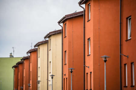 Blocks of red and yellow residential buildings under a cloudy sky at daylightの写真素材