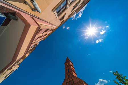 A low angle shot of church and colorful old tenement buildings in Torun, Polandの写真素材
