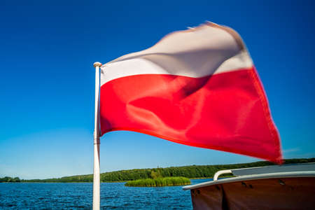 Polish flag fluttering on a boat on Jezioro Ostrowieckie in Polandの写真素材