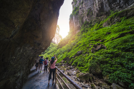Wulong, China - August 2019 : Tourists taking pictures of stunning scenery while walking on a narrow path in a canyon among karst landscape of the Wulong National Parkのeditorial素材