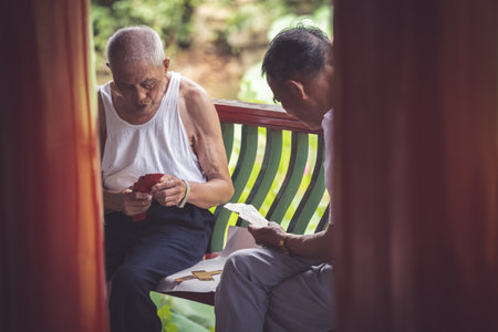 Chongqing, China - August 2019 : Two senior chinese men playing cards in public parkのeditorial素材