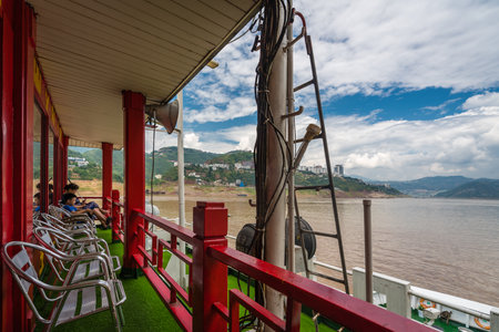Yangtze River, China - August 2019 : Tourists sitting on the first class observation deck on the luxury passenger cruise ship sailing through the gorge on the magnificent Yangtze Riverのeditorial素材