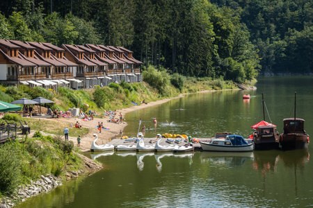 Zagorze Slaskie, Poland - August 2020 : Water cycle boats and small yachts in front of Holiday let homes and bungalows on the shore of Zagorze Slaskie reservoir lake, Lubachowskie Lake and Bystrzyca river valley landscape, Zagorze Slaskie, Lower Silesiaのeditorial素材
