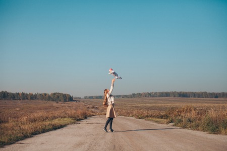A woman with a child in his arms on the road in the middle of a wastelandの写真素材