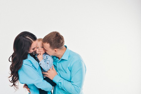 baby on the hands of parents on a white background.の写真素材