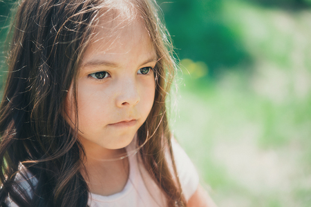Portrait of a girl on a background of green foliageの写真素材