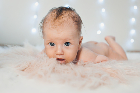 newborn baby lying on a white background. beautiful little boy lying on his tummy.の写真素材