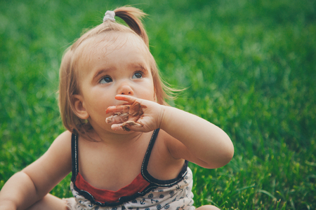 Portrait of little girl in a green grassの写真素材
