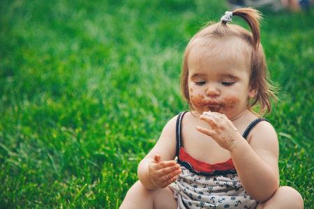 Portrait of little girl in a green grassの写真素材