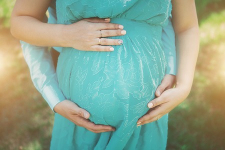 Pregnant woman in blue dress on flowers backgroundの写真素材
