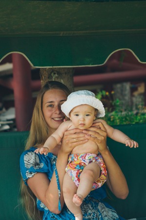 Portrait of a girl with baby on green backgroundの写真素材