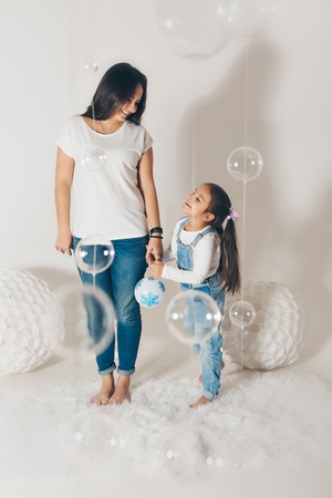 Portrait of a girl who holds her parents ' hands on a white background. Fashoin for women and girlsの写真素材