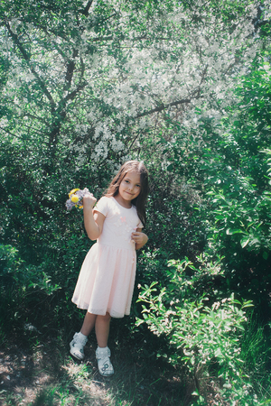 Portrait of a girl on a background of green foliageの写真素材
