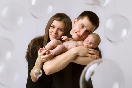 baby on the hands of parents on a white background.の写真素材