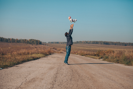 A man throws a child up on the road in the middle of the desertの写真素材