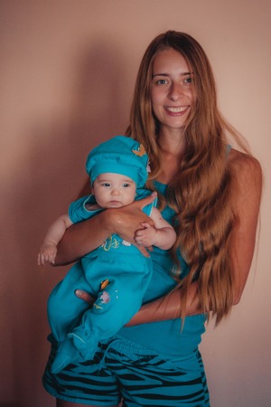 baby on the hands of mother. woman and child in blue