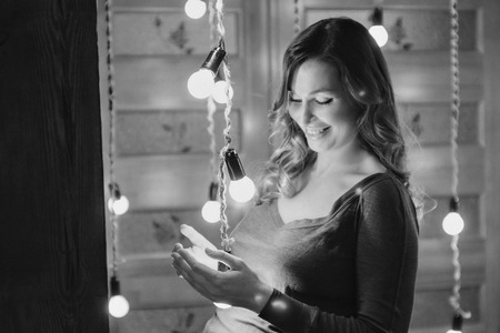 A pregnant woman on a lamps backgroundの写真素材