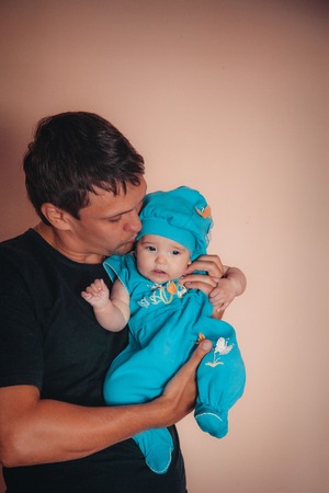 baby on the hands of father. man and child in a black and blueの写真素材