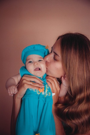 baby on the hands of mother. woman and child in blueの写真素材