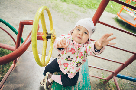 a ittle girl playing in the Playground. children's hand holding the steering wheelの写真素材