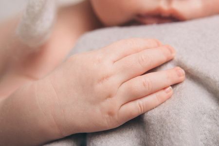 baby hands close up on a grey backgroundの写真素材