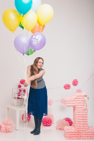 the blonde woman with the colored balls on a white background. Studio portrait of an attractive girl waiting for her birthday.の写真素材
