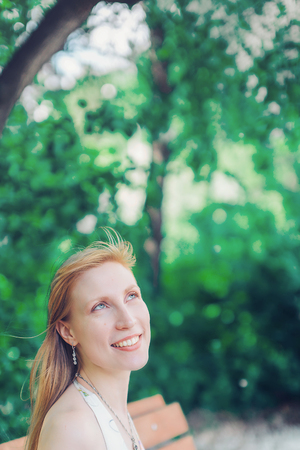 Portrait of a girl on a background of green foliageの写真素材