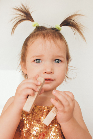 portrait of a little girl with tails on white background. Baby plays with toysの写真素材