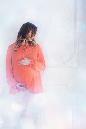 pregnant woman in red and white on a white backgroundの写真素材