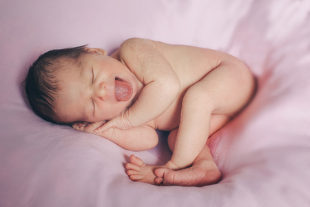 Portrait of newborn baby on a pink background.の写真素材