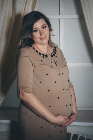 a pregnant woman holding hands on bellyの写真素材