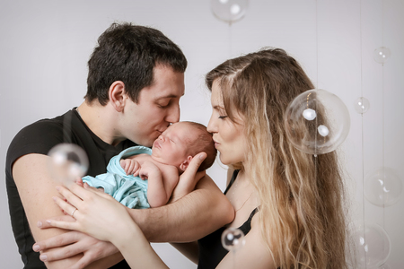 baby on the hands of parents on a white background.の写真素材