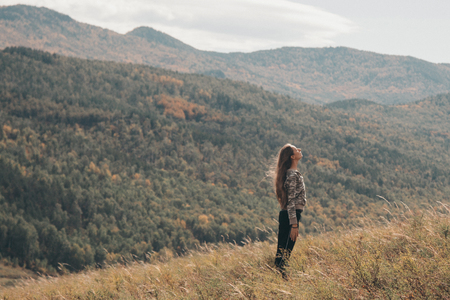 The man on the background of wild nature. Russian mountains, plains, fields. Photo of a woman in full heightの写真素材